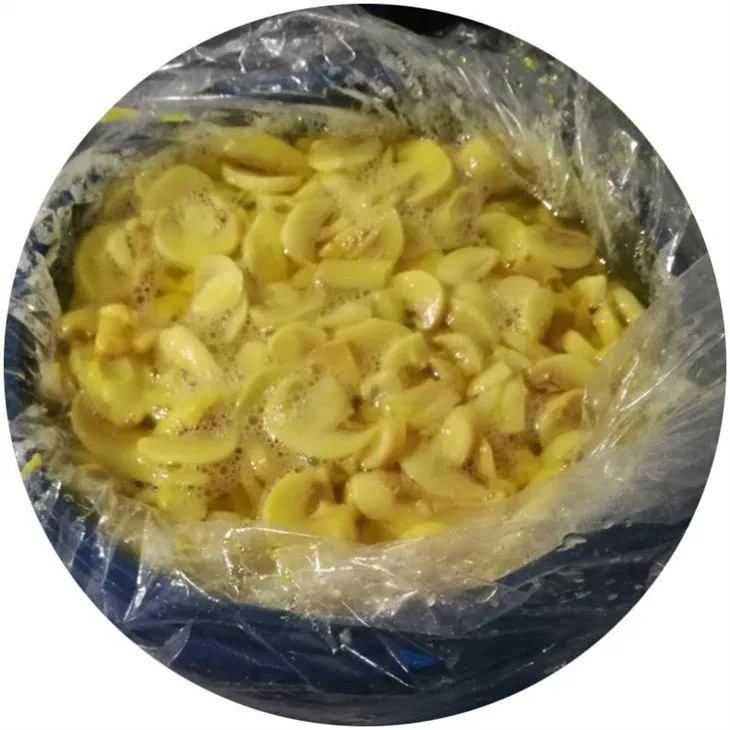Sliced white mushroom in brine in drums